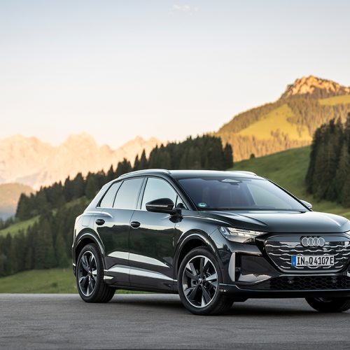 Audi Q4 SUV e-tron in Tamboragrey, outdoor static shot, exterior, three-quarter front view set against an alpine landscape.