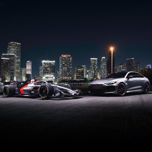 The Audi RS 5 next to the Audi R26 in front of the skyline of Miami by night. The RS 5 makes its debut at the Formula 1 Miami Grand Prix as a car for the F1® Pirelli Hot Laps